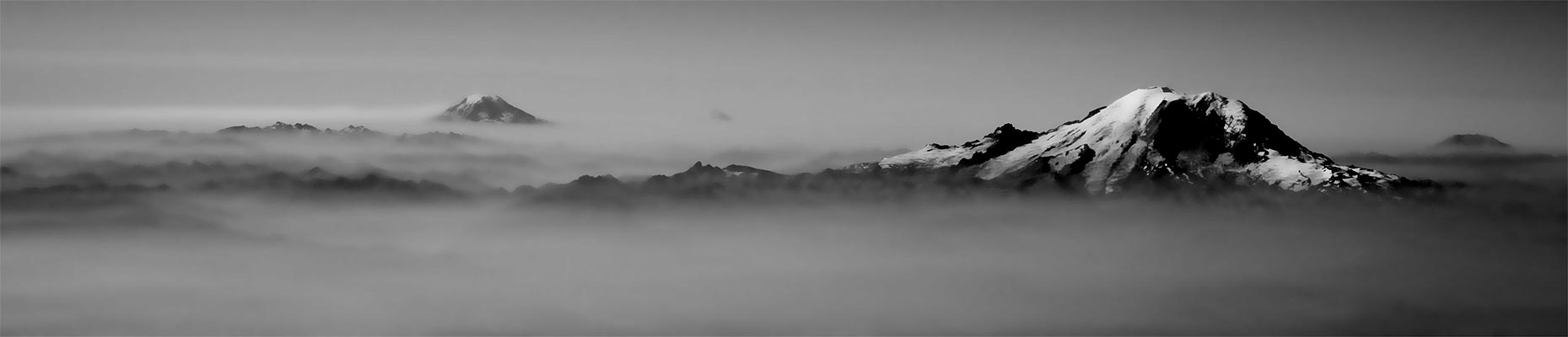 Mount Rainier and Mount Adams rising above a sea of cloud, in black and white